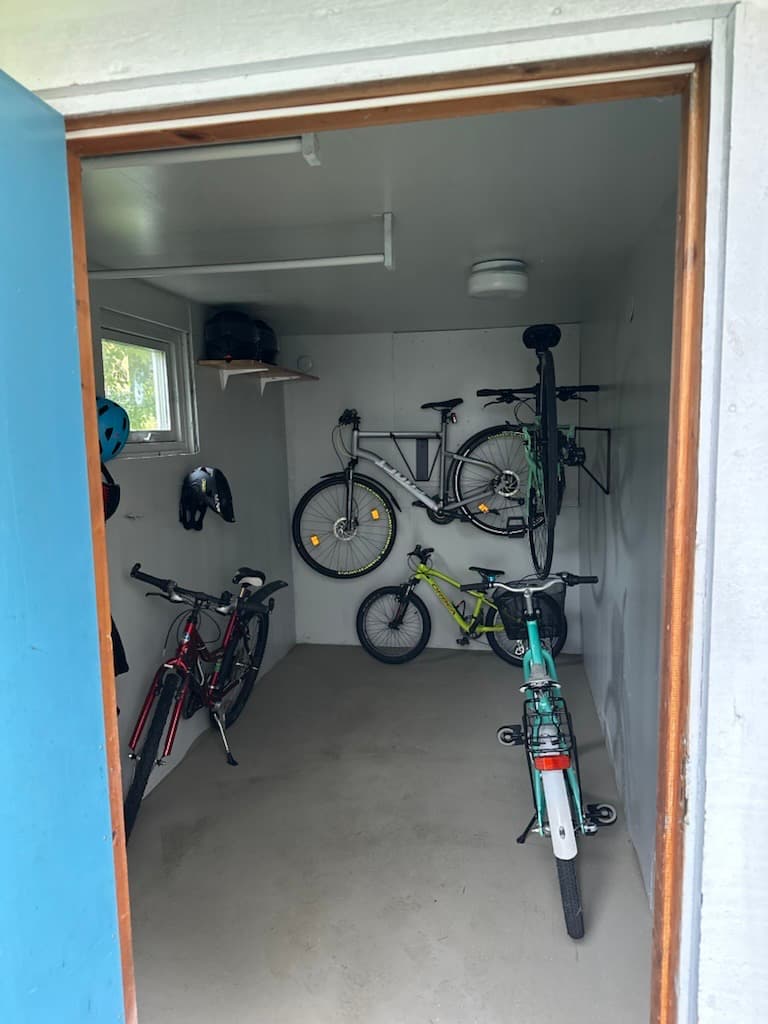 Förråd i Kinna efter enklare renovering, med vitmålade väggar och cyklar på väggfästen.